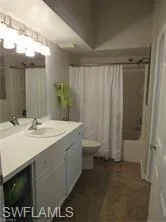 Full bathroom with shower / tub combo with curtain, vanity, and toilet