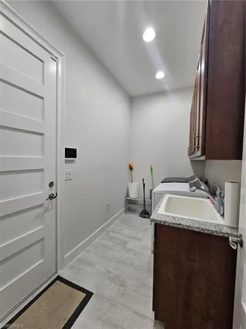 Laundry area with cabinet space, recessed lighting, light wood-style flooring, and washer / dryer