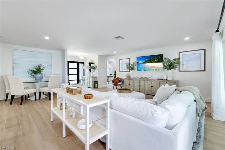Living area with baseboards, recessed lighting, visible vents, and light wood-style floors