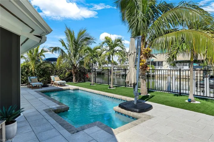 View of pool with a patio, fence, a fenced in pool, and a yard