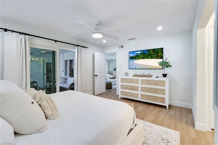 Bedroom featuring baseboards, visible vents, access to outside, and light wood finished floors