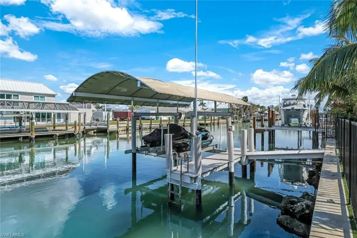 Dock area featuring boat lift and a water view