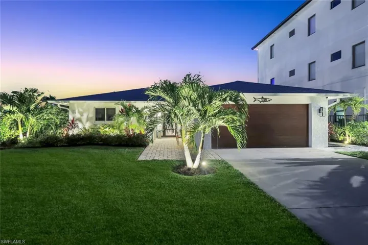 View of front of home featuring stucco siding, an attached garage, concrete driveway, and a yard