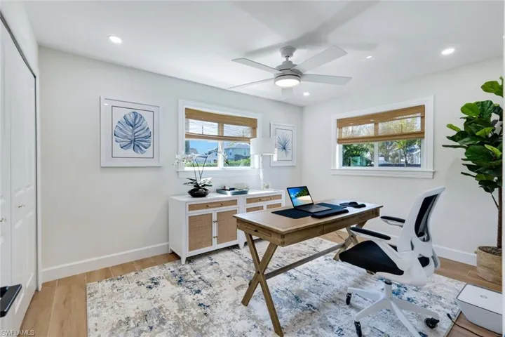 Office space featuring baseboards, ceiling fan, light wood-style flooring, and recessed lighting