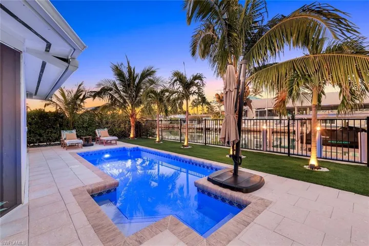View of swimming pool with fence, a fenced in pool, a patio, and a lawn