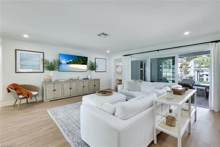 Living room with baseboards, visible vents, light wood-style floors, and recessed lighting