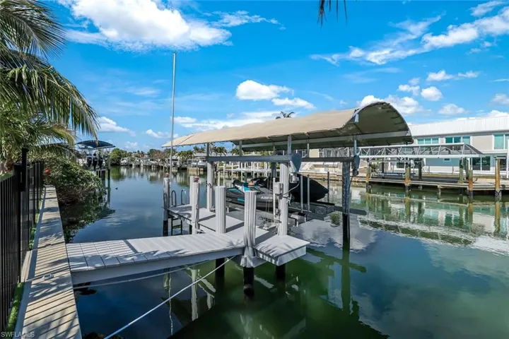 View of dock with boat lift and a water view