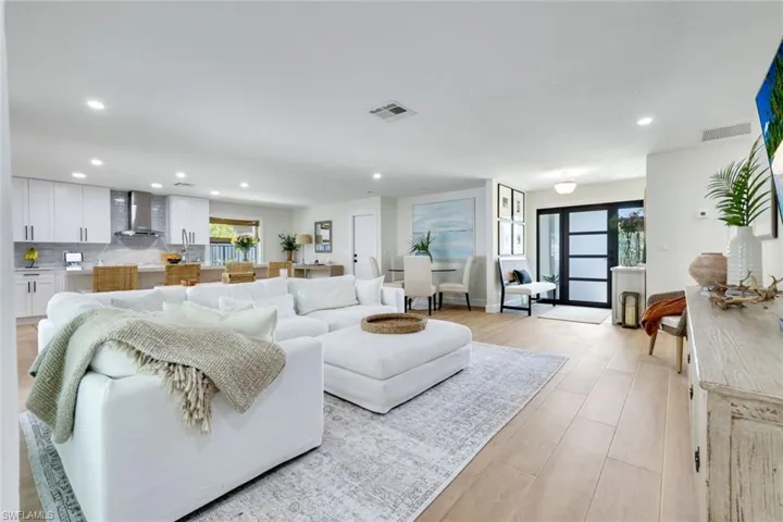 Living area with a wealth of natural light, visible vents, recessed lighting, and light wood finished floors