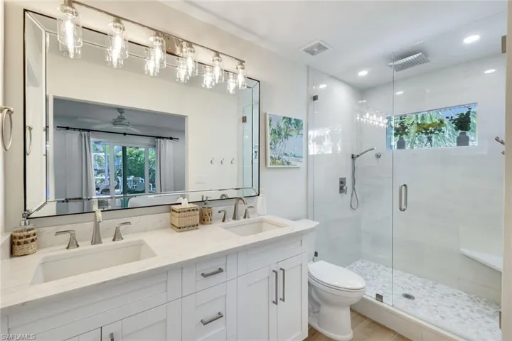 Bathroom featuring visible vents, a sink, and a shower stall