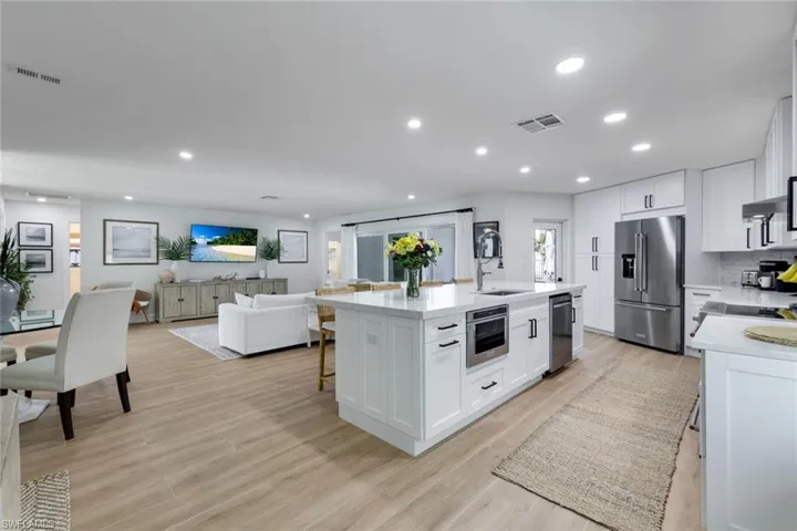 Kitchen with light wood-type flooring, a sink, appliances with stainless steel finishes, and visible vents