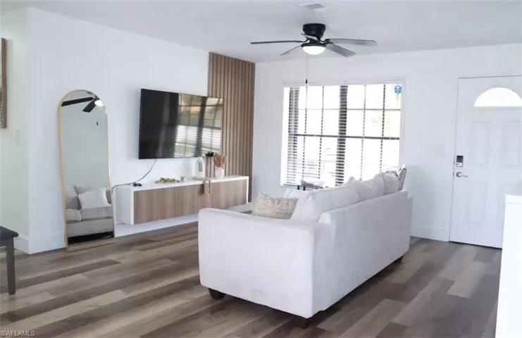 Living area featuring a ceiling fan, wood finished floors, and healthy amount of natural light