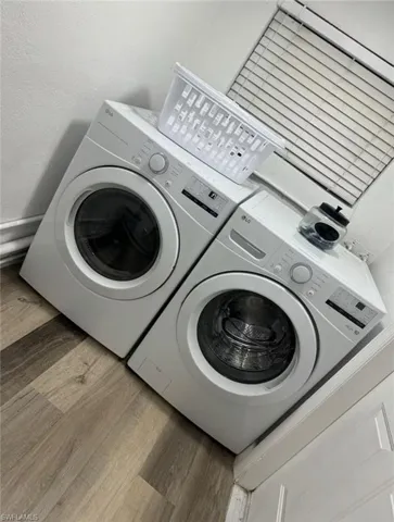 Laundry area featuring washing machine and clothes dryer and wood finished floors