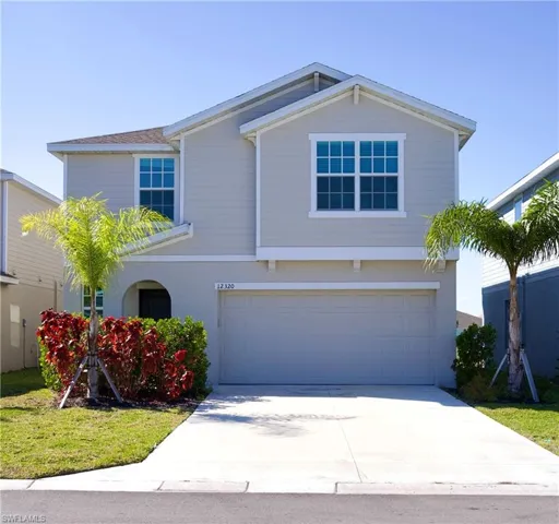 View of front of property featuring an attached garage, concrete driveway, and stucco siding