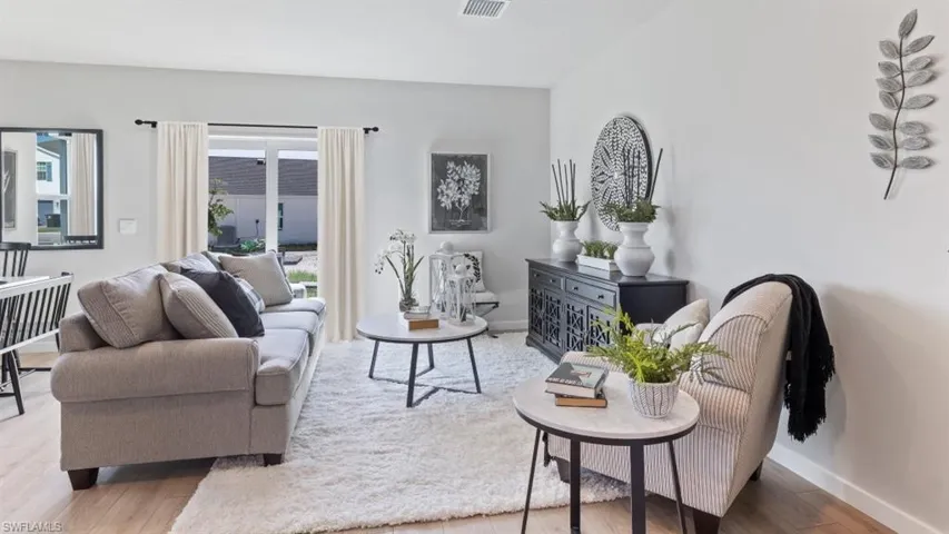Model home. Living area featuring wood finished floors and baseboards
