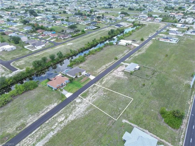 Cleared residential lot outlined in white, situated on a paved street