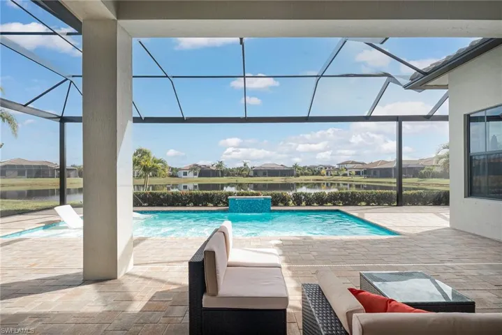 Swimming pool with a covered porch area, uncovered patio area, picture window lanai overlooking water view