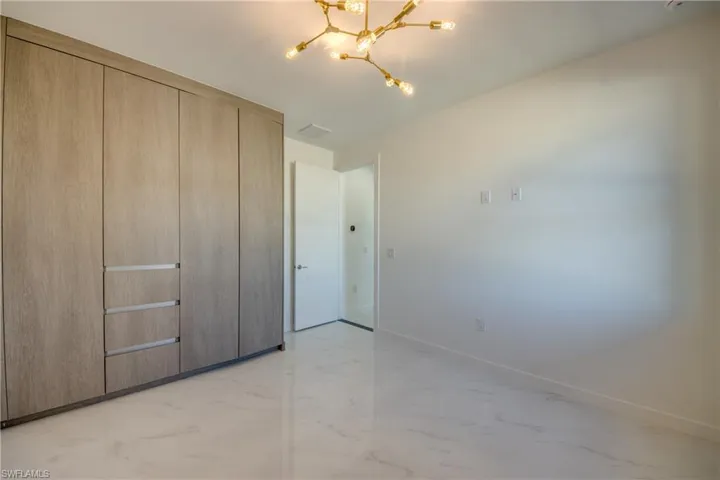 Unfurnished bedroom featuring a closet and an inviting chandelier