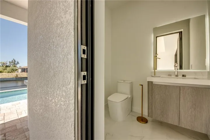 Pool Bathroom with a wealth of natural light, sink, and toilet