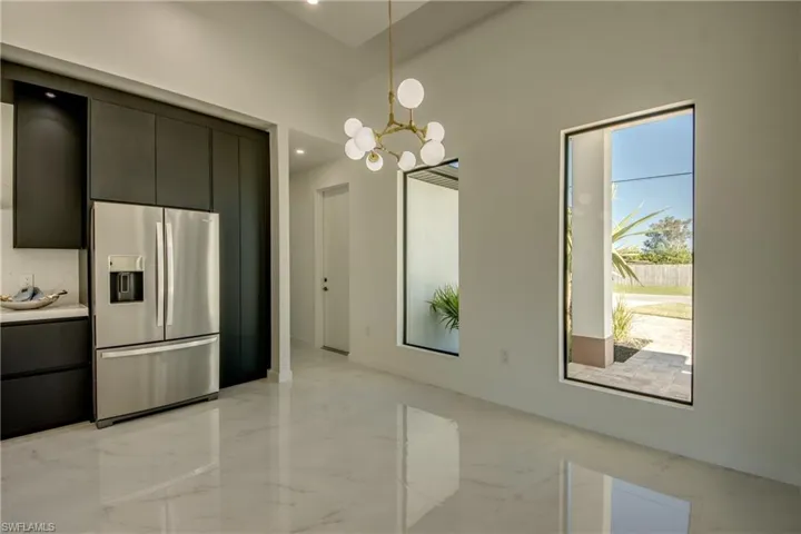 Kitchen with a chandelier, stainless steel fridge, and pendant lighting