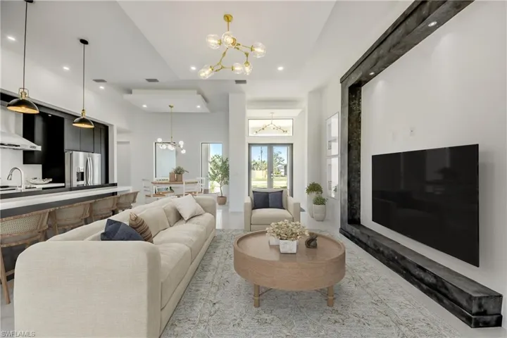 Virtually staged Living room featuring an inviting chandelier, sink, a towering ceiling, and french doors