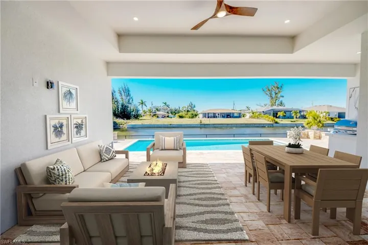 Virtually staged View of pool with a grill, a patio area, an outdoor living space with a fire pit, and ceiling fan