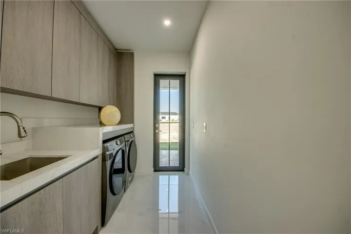 Washroom featuring cabinets, sink, and washer and dryer