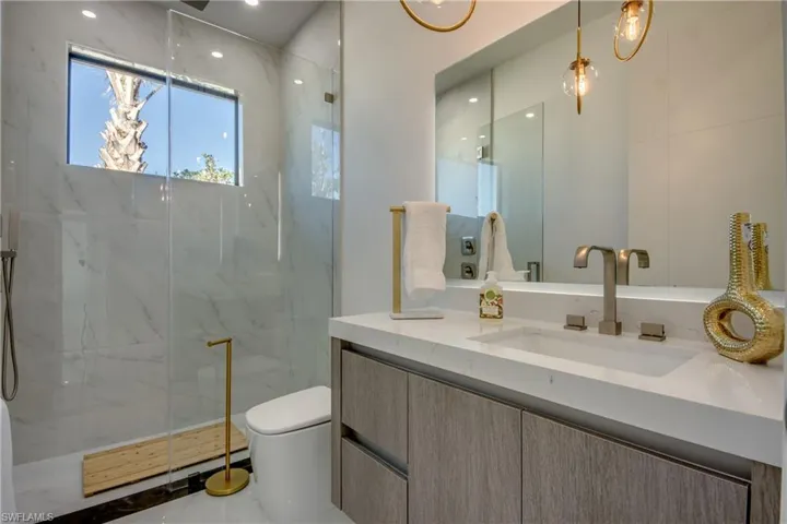 Bathroom featuring vanity, toilet, and walk in shower