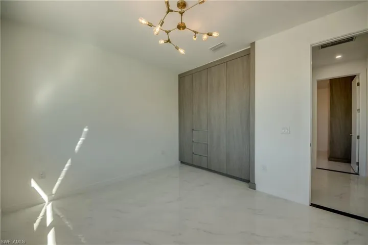 Unfurnished bedroom with a closet and a chandelier