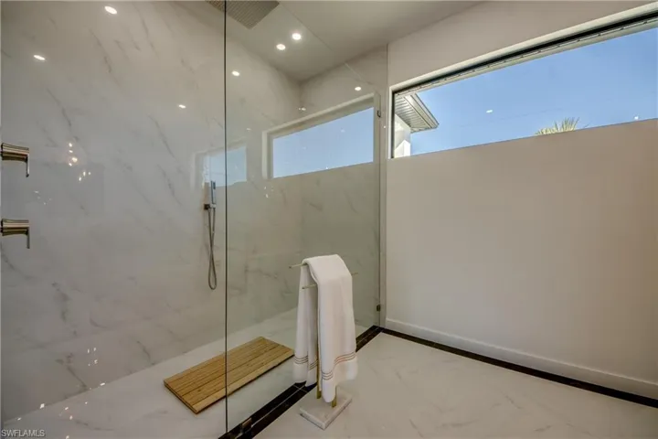 Bathroom featuring plenty of natural light and a shower with shower door