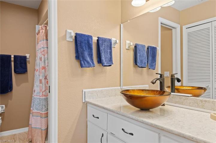 Primary bathroom has a vessel sink and walk in closet