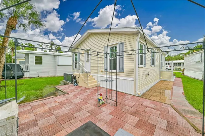Back of property featuring a lawn and a patio area