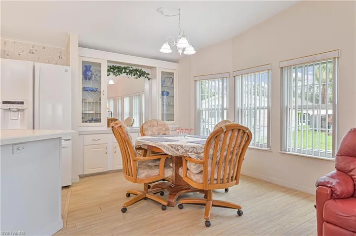 Dining room featuring an inviting chandelier, light wood-type flooring, and a healthy amount of sunlight