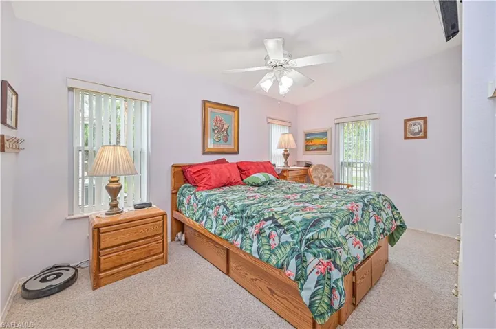 Carpeted bedroom with lofted ceiling and ceiling fan