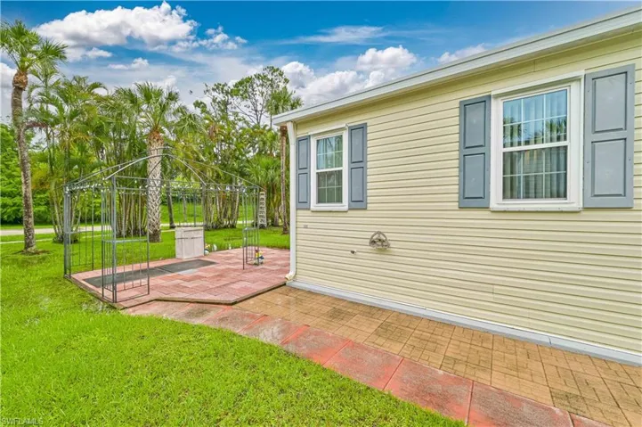 View of property exterior with a patio and a yard