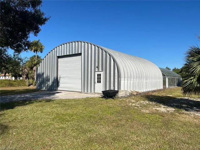 View of outdoor structure featuring driveway