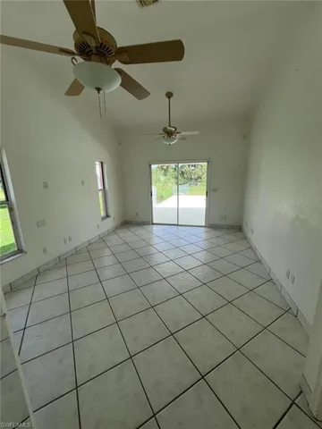 Unfurnished room with light tile patterned flooring and ceiling fan