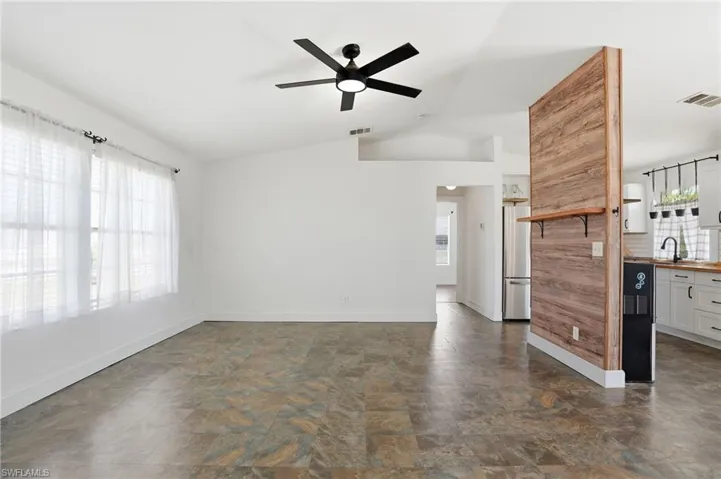 Expansive living area with vaulted ceilings and a ceiling fan