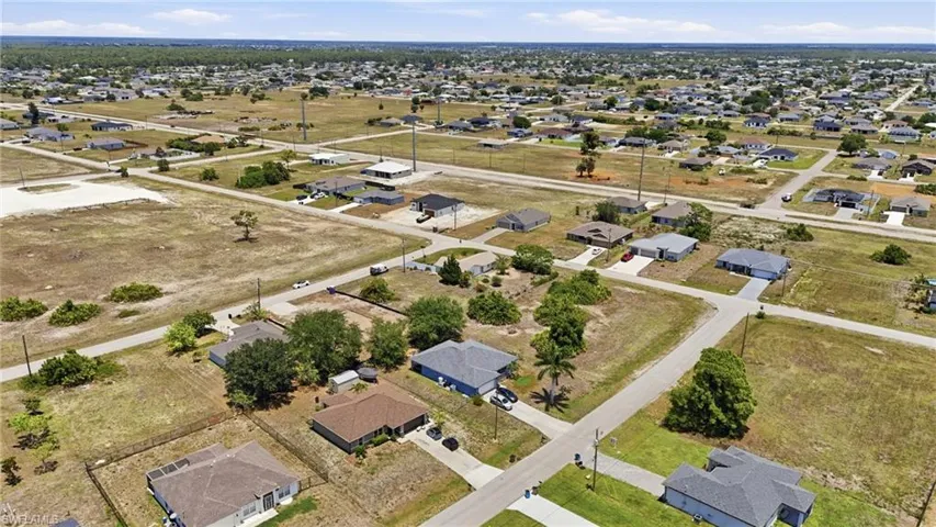 Aerial perspective showcasing a residential area with single-family homes and undeveloped land parcels