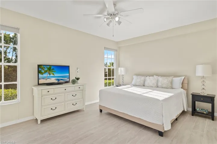Bedroom featuring light wood-style flooring, baseboards, and ceiling fan