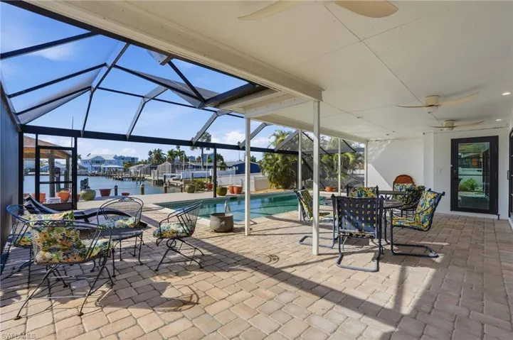 Screened lanai featuring a paver patio and water frontage - Virtually Edited Image