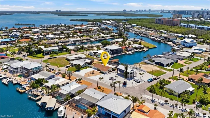 Aerial overview of a waterfront neighborhood featuring canals, residential properties, and distant city skylines - Virtually Edited Image