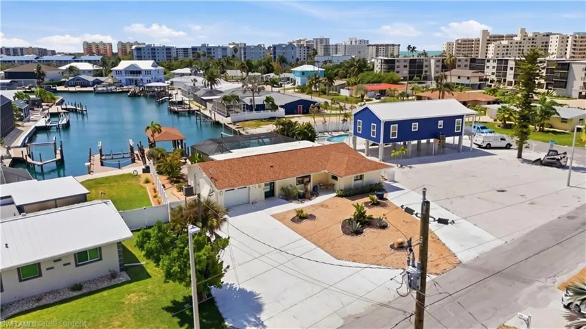 Waterfront property featuring a private dock with multiple boat slips, a covered boat lift, and direct canal access - Virtually Edited Image