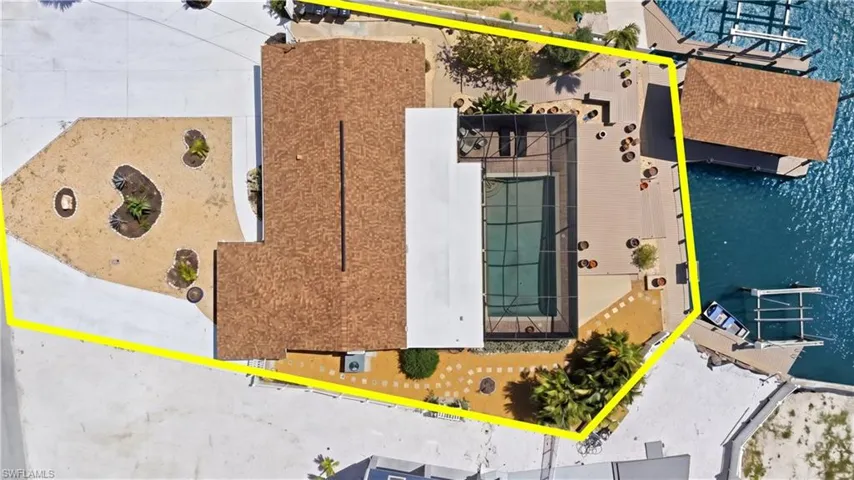 Waterfront property with private boat dock, screened swimming pool, and extensive patio areas - Virtually Edited Image