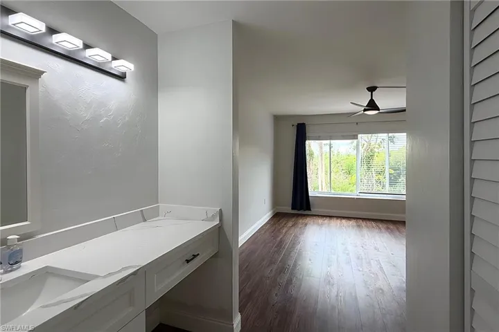 Bathroom with vanity, dark wood-style flooring, and a ceiling fan