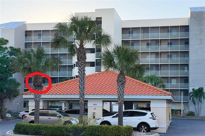 View of apartment building / complex featuring uncovered parking