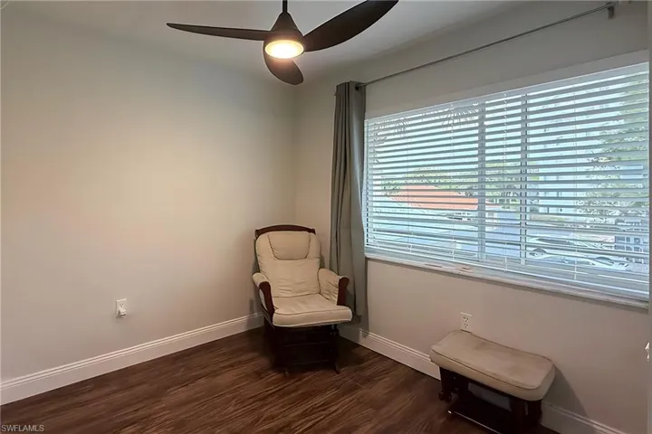 Living area with dark wood-style floors and ceiling fan