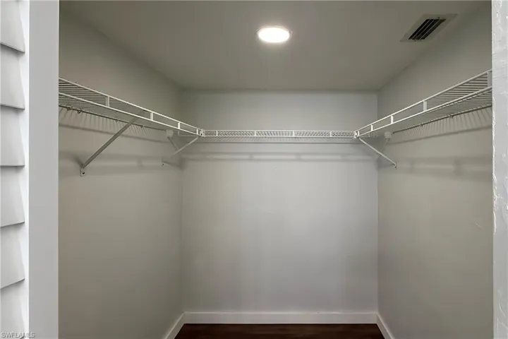 Walk in closet featuring dark wood-style floors