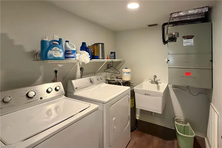 Laundry area featuring heating unit, dark wood-style flooring, and independent washer and dryer
