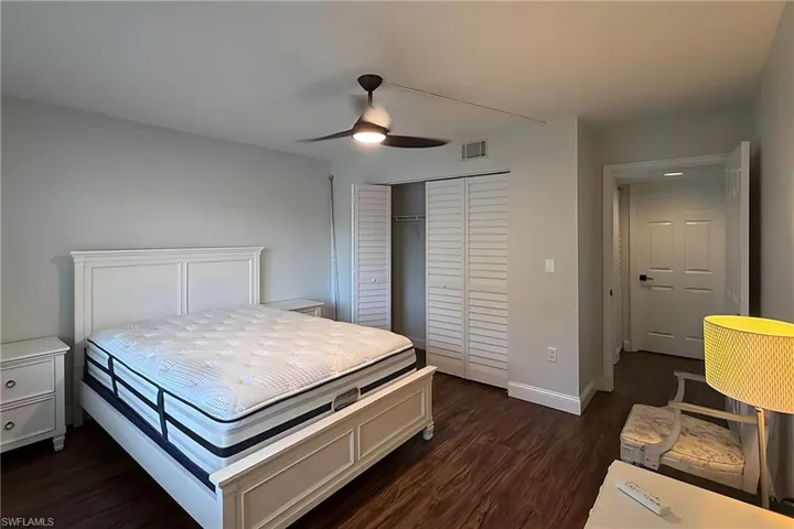 Bedroom featuring dark wood-type flooring, a ceiling fan, and a closet