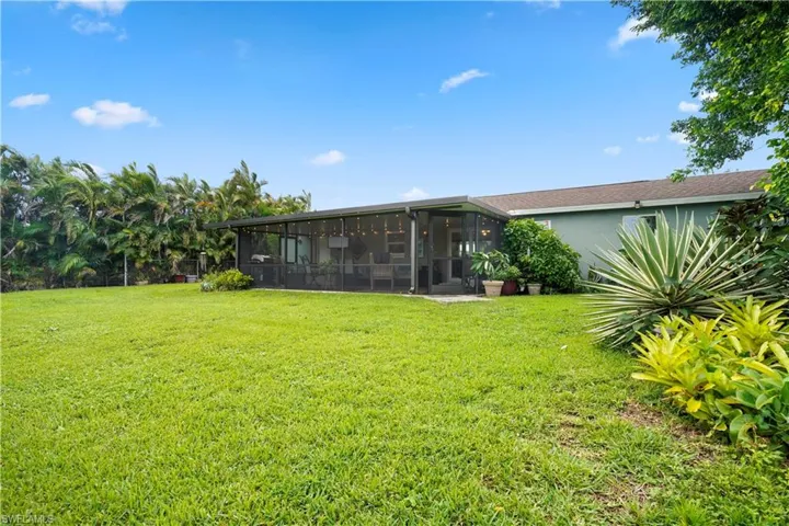 View of yard featuring a sunroom. Beautiful native landscape!